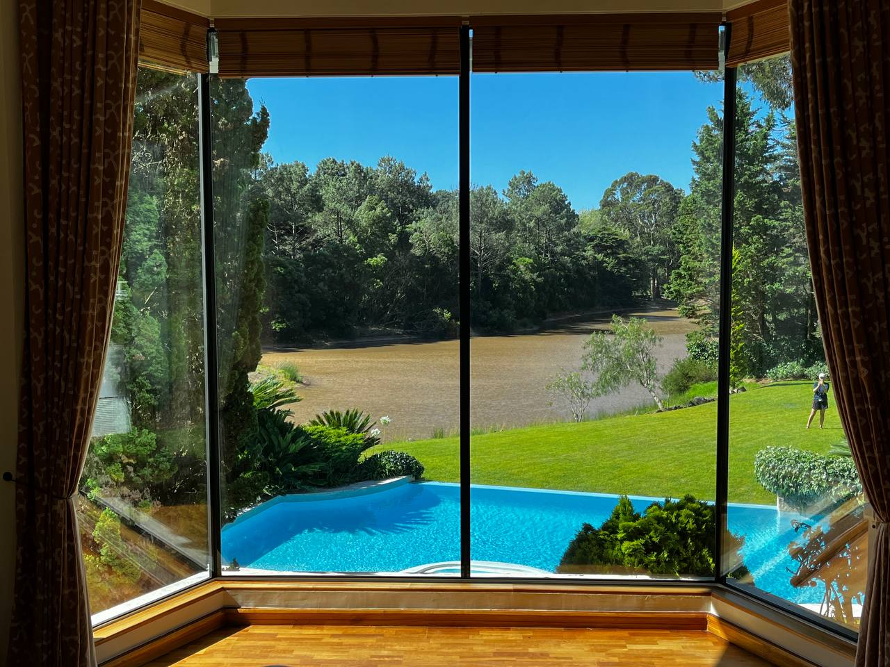 Interior depois da renovação Aestech, com grandes superfícies de vidro voltadas para o jardim e piscina